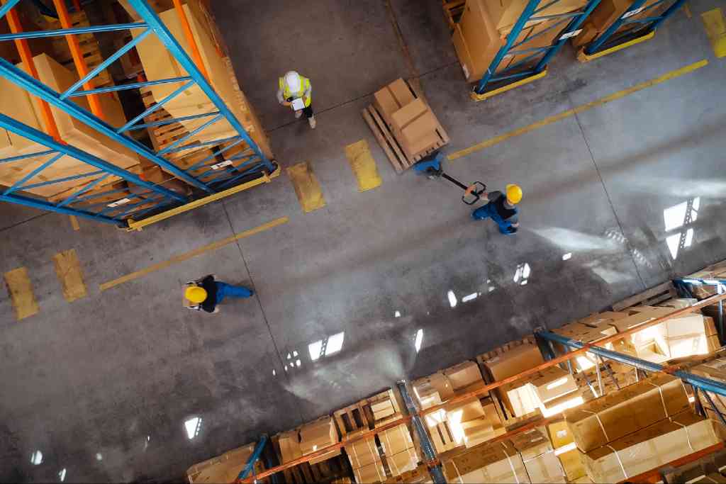 warehouse workers and a manager tracking inventory kpis